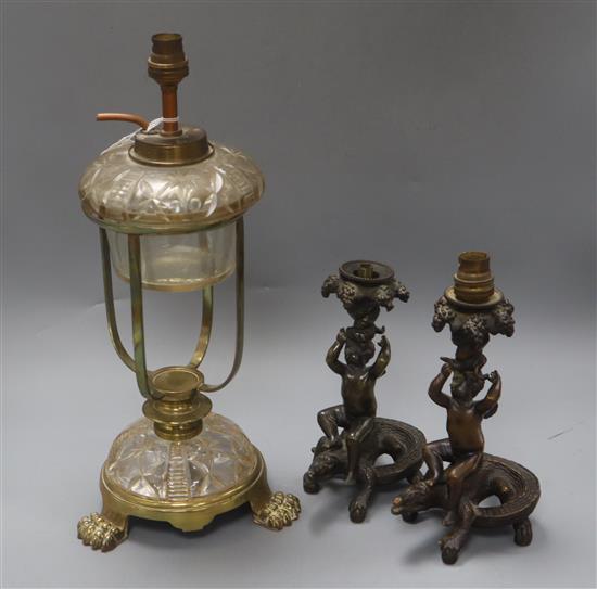 Two bronze putti candlesticks converted to lamps and a glass lamp